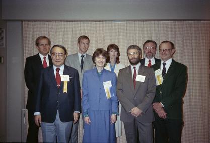 Ruth Dayhoff at the MUMPS Users Group International meeting, an organization which she helped found.  Other in picture include: Richard Walters (front row left to right), Jon Diamond, Ruth Dayhoff, Ichiro Wakai, Richard Davis (back row left to right), Mau