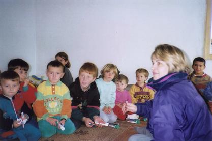 Maria Herran with children in Kosovo, 1998