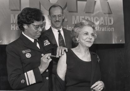 Acting Surgeon General Audrey Forbes Manley giving advice columnist Ann Landers a flu shot, ca. 1996