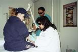 Nancy E. Jasso removing a tattoo from a patient's arm, ca. 2001